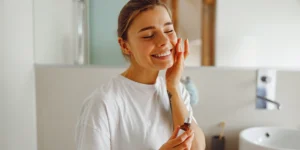 Mujer joven realizandose una rutina de limpieza facial
